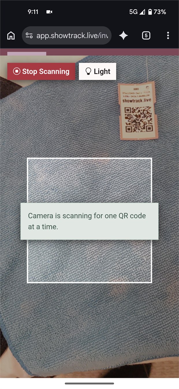 ShowTrack mobile receiving scanner pointing at an inventory QR tag